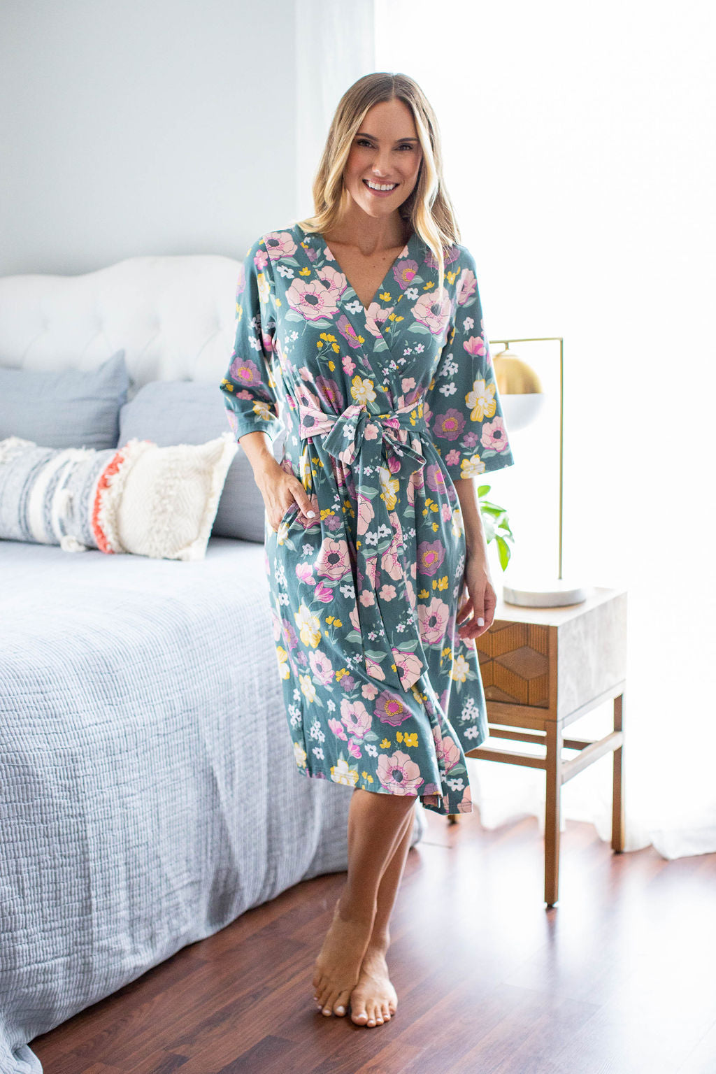 Charlotte maternity robe with pockets, belt closure, and knee length. 3/4 sleeve length for IV access. Pink and yellow flowers against green background.